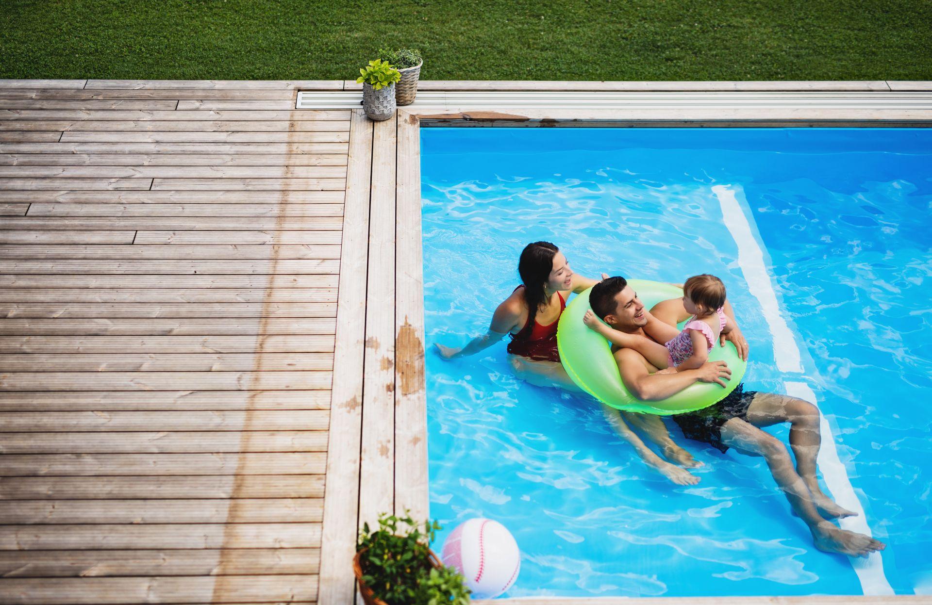 Familie mit kleinem Kind im Pool Komplettset mit Holzdeck, Vater im Schwimmring